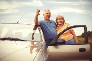 Two elderly people nesr car with keys